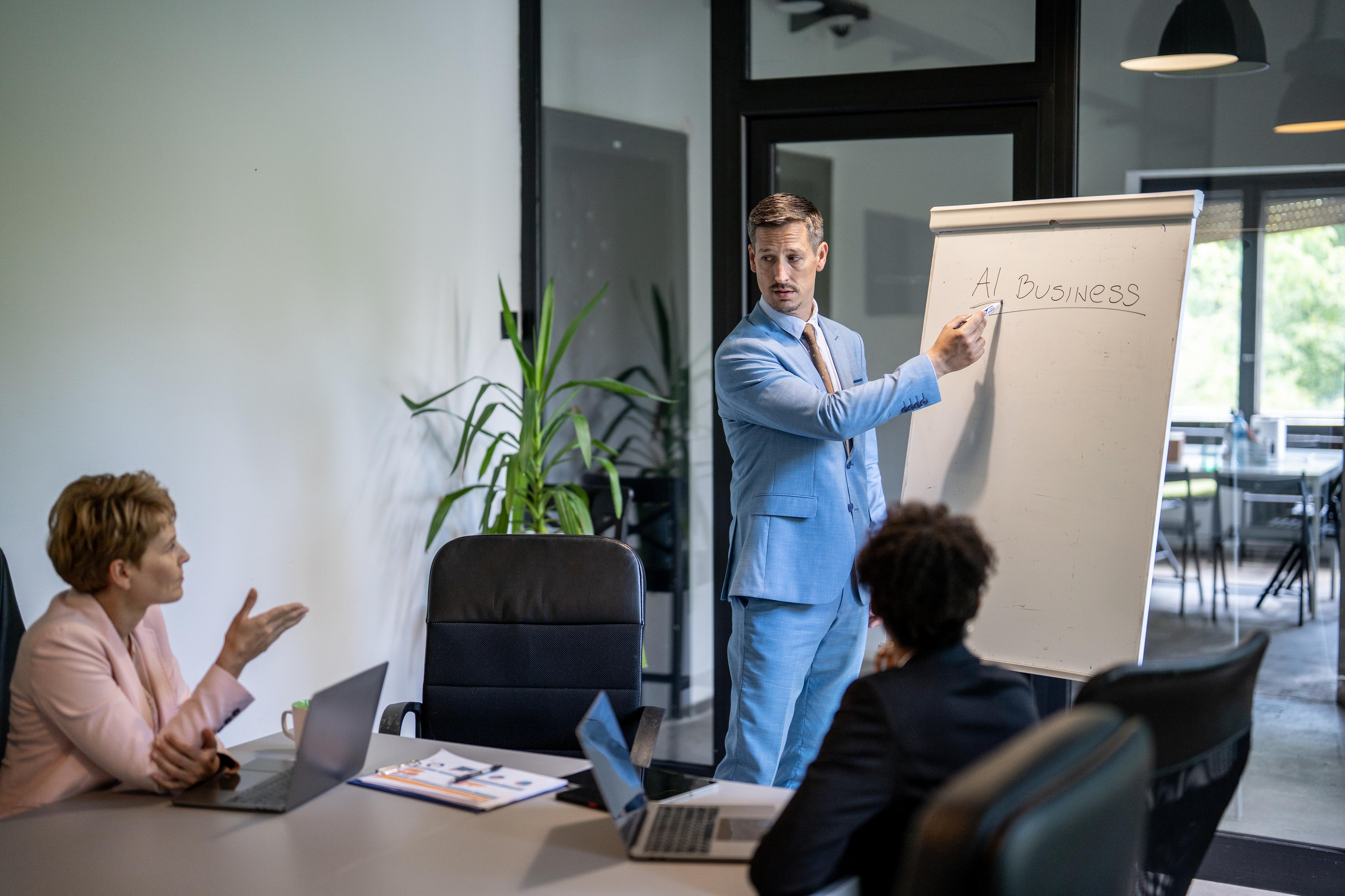 business team meeting discussing AI strategy and marketing insights with presentation board showing AI business concepts in office